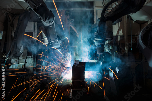 Industrial welding robots are welding in production line