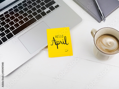 Hello April hand writing on sticky note on work desk