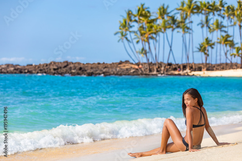 Beach bikini summer holiday hawaii vacation woman travel lifestyle. Asian girl relaxing enjoying sun on holidays. © Maridav