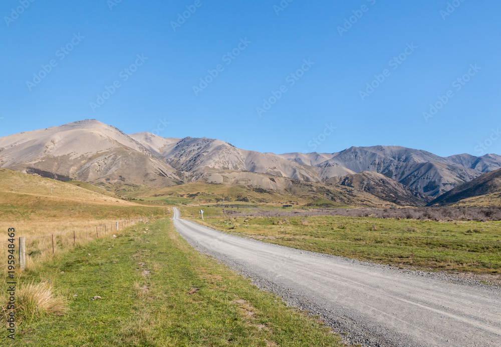 country road across barren hills in Southern Alps around Molesworth Station, South Island, New Zealand