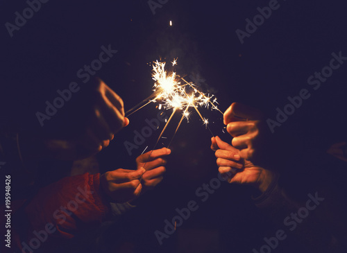 Picture showing group of hand having fun with sparklers.