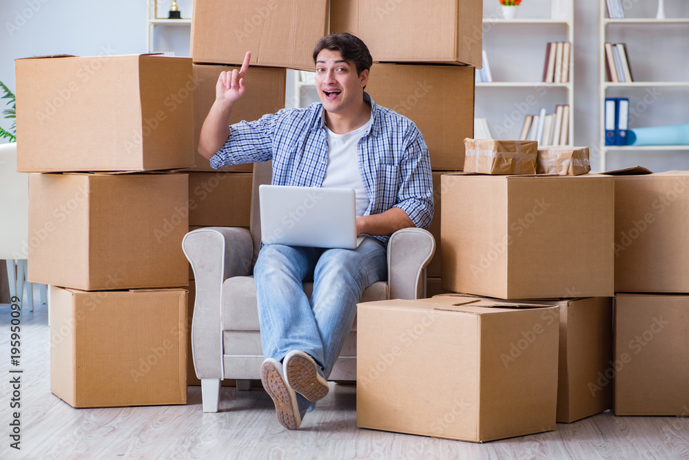 Young man moving in to new house with boxes Young man moving in to new house with boxes