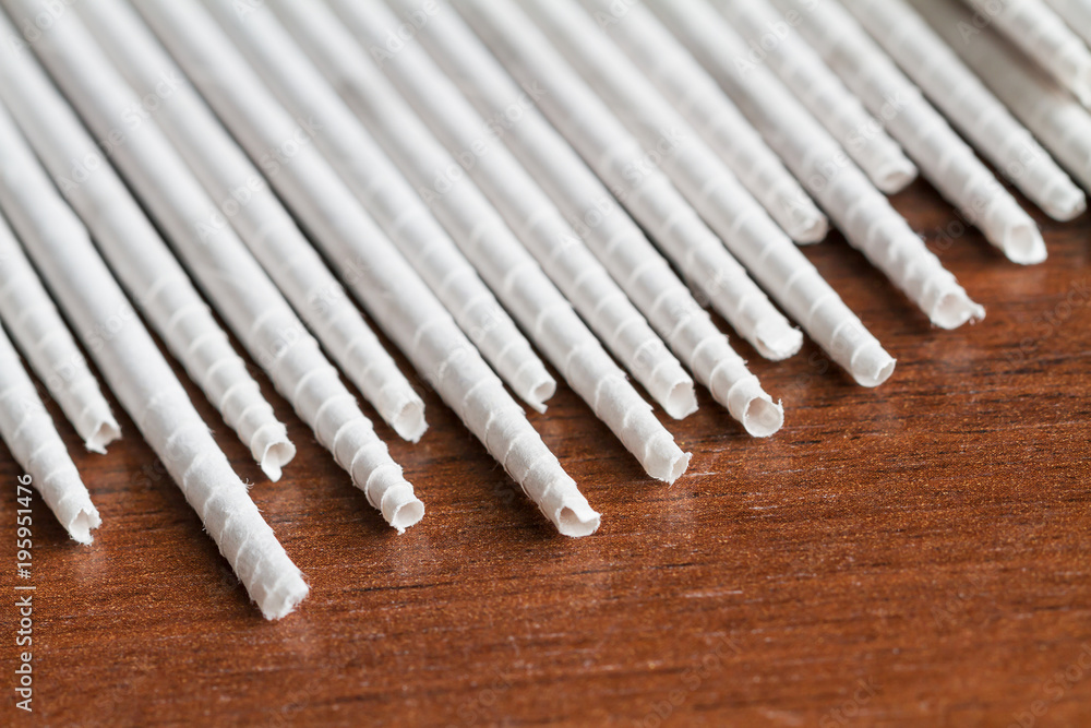 White newspaper tubules for newspaper weaving. Closeup, selective focus. White newspaper tubules for newspaper weaving. Closeup, selective focus.