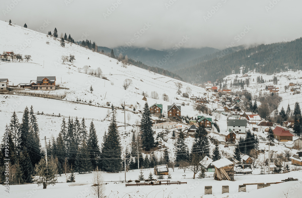 Picturesque panorama of a village in the Carpathian Mountains in Eastern Europe. Rustic winter landscape
