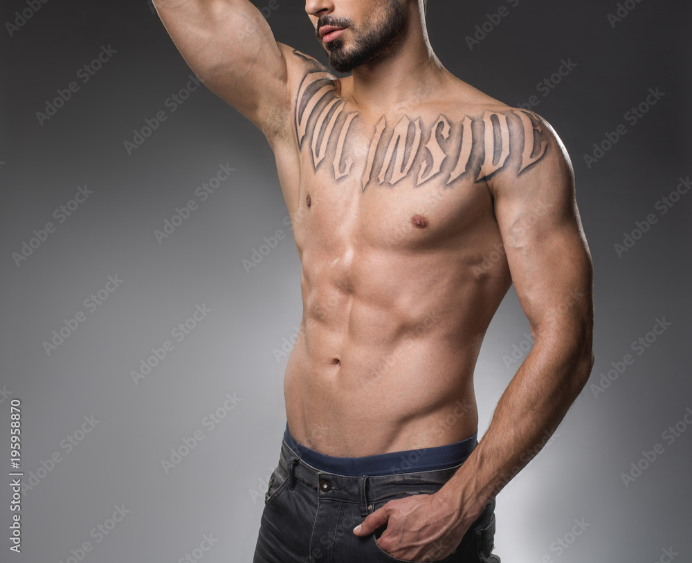 Obraz premium Tranquil sinewy macho posing topless. Copy space in left side. Isolated on background