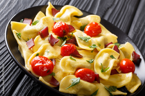 Delicious dumplings casoncelli with ham, cherry tomatoes and greens close-up. horizontal