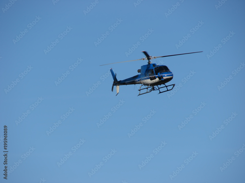 Blue helicopter flying on blue sky Blue helicopter flying on blue sky