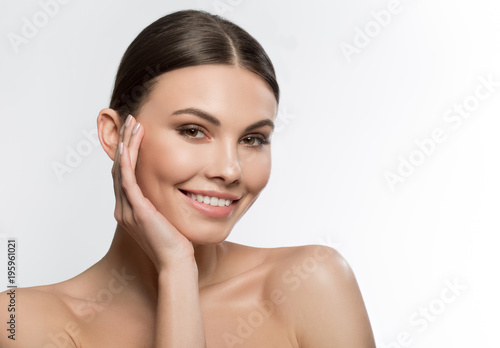 I like my skin. Portrait of happy girl touching her face with satisfaction and smiling. Isolated and copy space