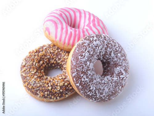Assorted doughnuts in the glaze, colorful sprinkles and nuts on a white background.
