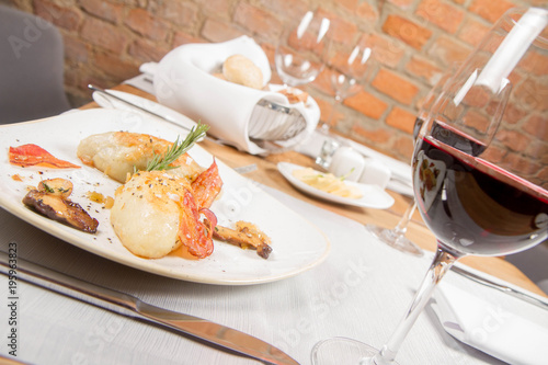 Traditional polish dish called kartacz - potato dumplings stuffed with meat and served with crispy bacon, caramelized onion and fried boletus photo