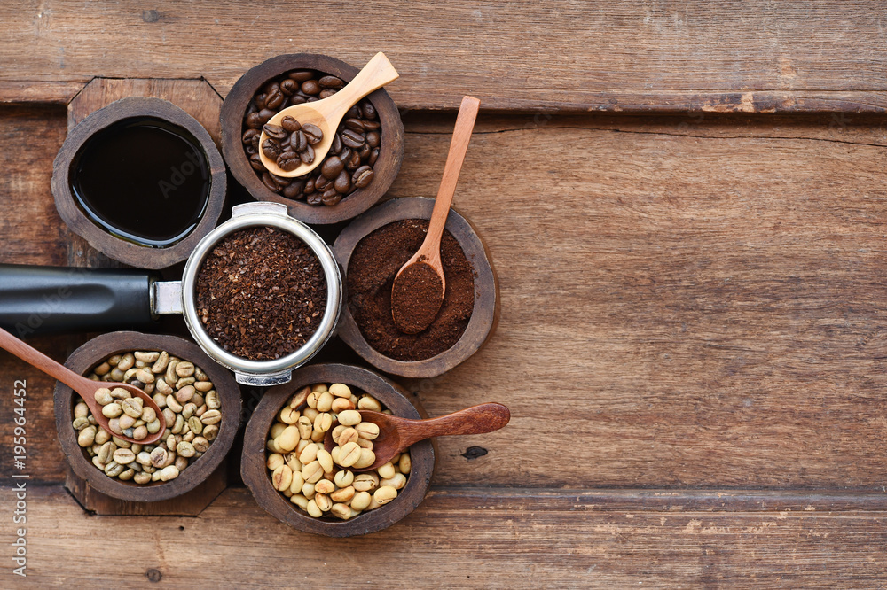 Freshly ground coffee beans in a metal filter and coffee beans in bowl on wooden background