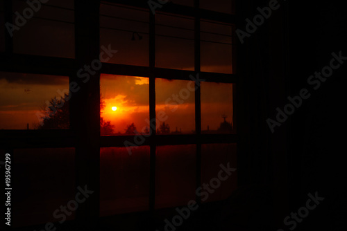 Landscape: fiery, bright sunset in the window