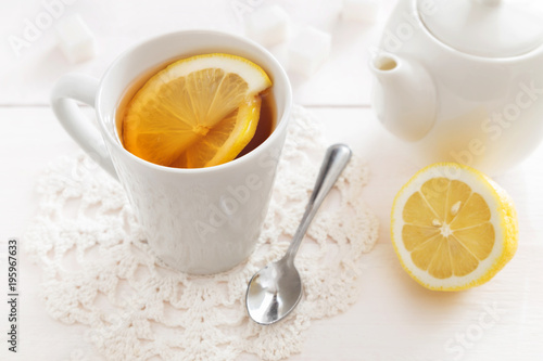 Cup of lemon tea and a teapot