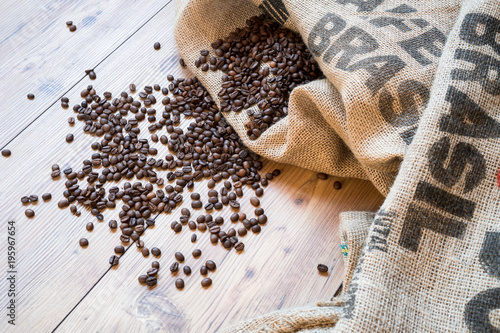 coffee beans on jute sack and printed Brasil on wooden floor background. bag of coffee