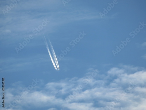 Trace of the Jet airplane in the cloudy blue sky. Falling plane concept