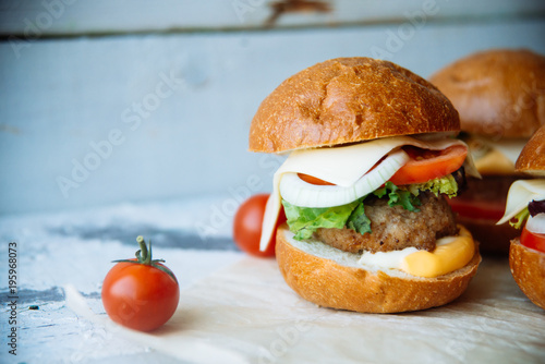 The traditional hamburger Patty, cheese, tomato, lettuce, beef Burger, takeaway. Dark wooden background, horizontal shot. photo