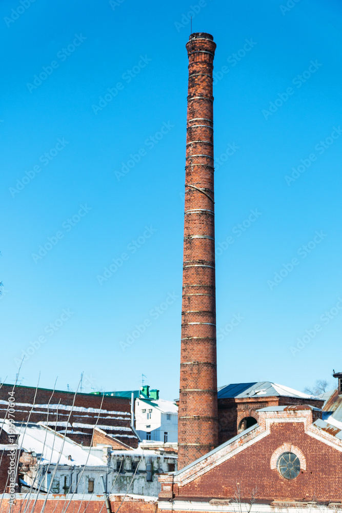 Old factory chimney on background of blue sky