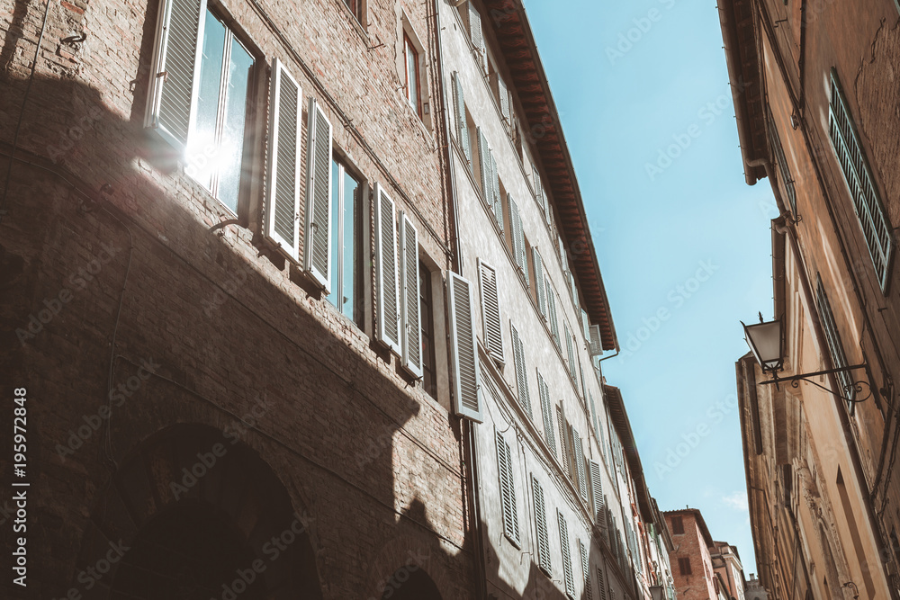 Sun reflecting in window of old building in Siena