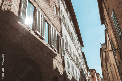 Sun reflecting in window of old building in Siena