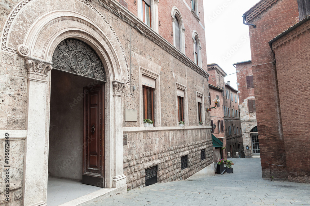 Old arch door in building facade in Siena