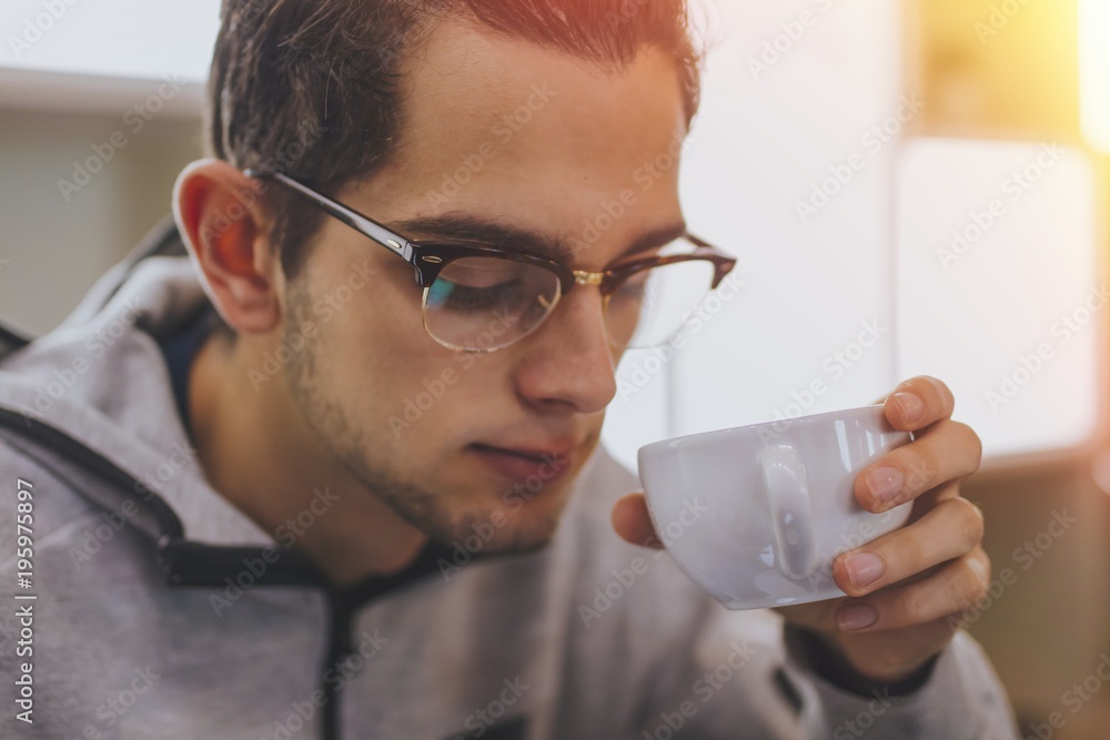 portrait of trendy young man taking coffee