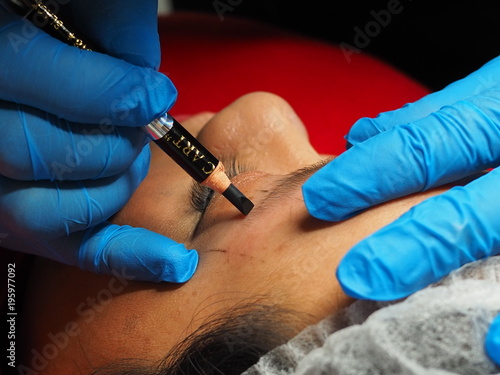 Eyebrows tattoo - Cosmetologist preparing permanent make-up for eyebrows