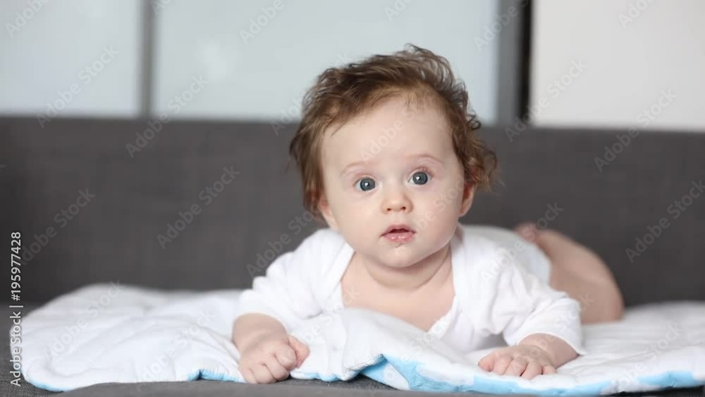 little child lying down on sofa at home and looking around little child lying down on sofa at home and looking around