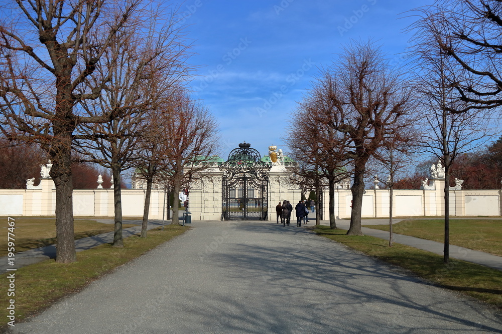 Aleja wiodąca do pięknej bramy wejściowej pałacu Belvedere, Wiedeń, Austria, piękna wczesnowiosenna pogoda, błękitne niebo, grupa turystów przed wejściem - obrazy, fototapety, plakaty 