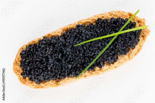 Canapes with black sturgeon caviar and spice isolated on the white background.