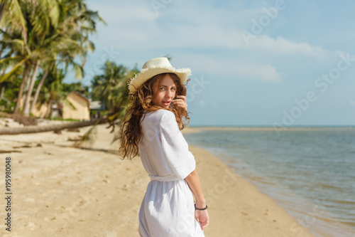 attractive girl walking on tropical sandy beach at the ocean