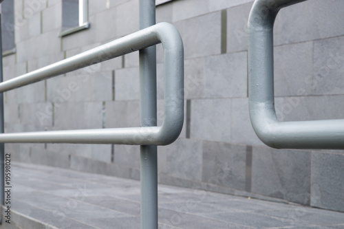 Metal pipe railings of the ramp near the building.
