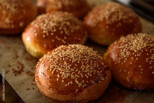 homemade burger rolls sprinkled with sesame seeds are baked in the oven © Mikhaylovskiy 