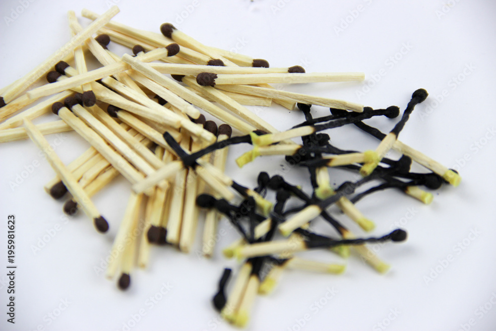 A bunch of burnt and whole matches on a white background A bunch of burnt and whole matches on a white background