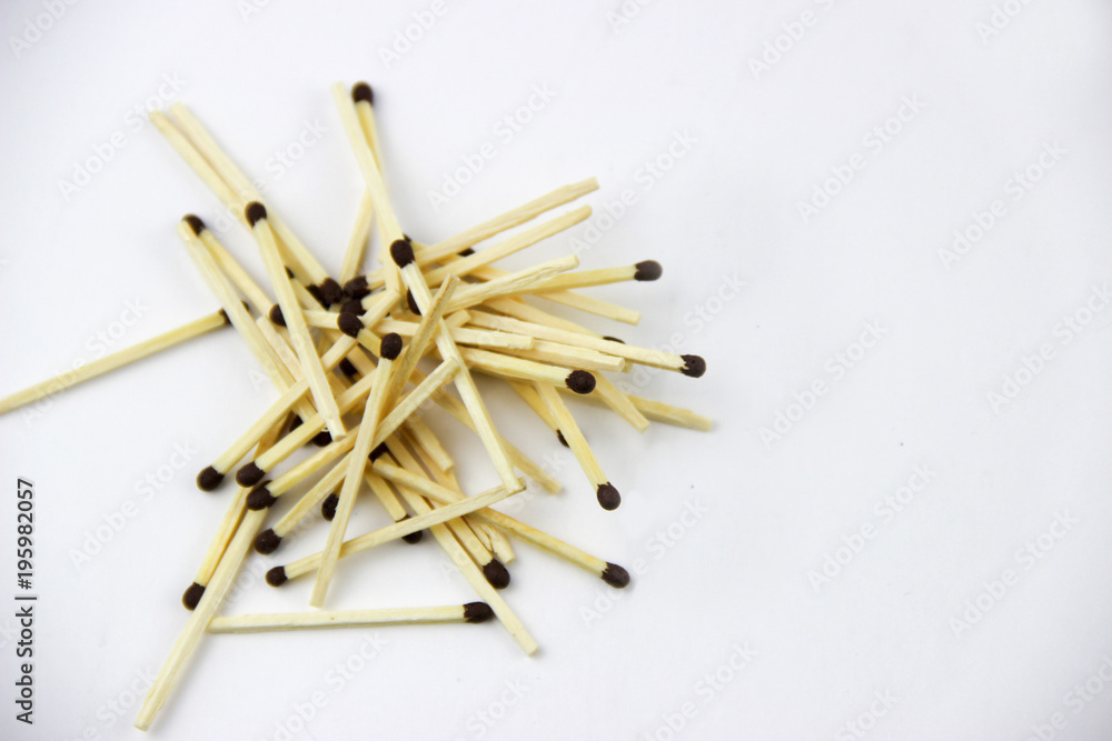 A bunch of burnt and whole matches on a white background A bunch of burnt and whole matches on a white background
