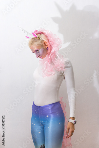 Pink cute sexy girl unicorn on white background. young woman close up portrait. Halloween costume photo