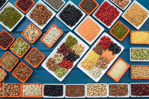 Different dry legumes in container on blue plank, Multicolor dried beans for eating healthy