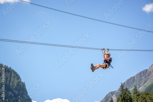 Teenager having fun on a zip line in the Alps, adventure, climbing, via ferrata during active vacations in summer