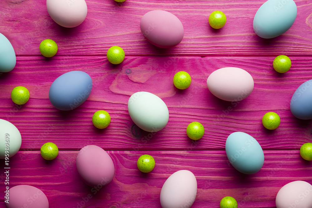 Colored Easter eggs and green balls on pink wooden background Colored Easter eggs and green balls on pink wooden background
