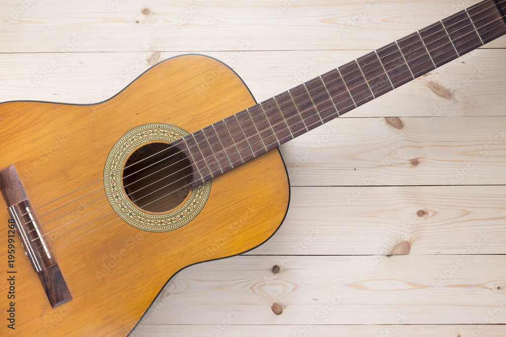 Acoustic guitar on a wooden background top view Acoustic guitar on a wooden background top view