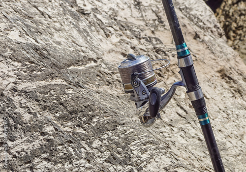 fishing rod with reel between the rocks ready to be used