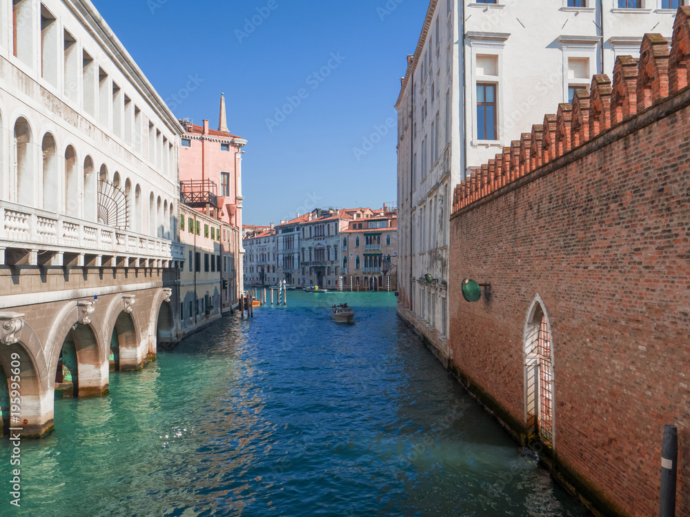 stunning view on a bright waterway with beautiful buildings that leads into the Grand Canal in Venice, Italy