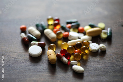 Medications and tablets on a wooden texture table
