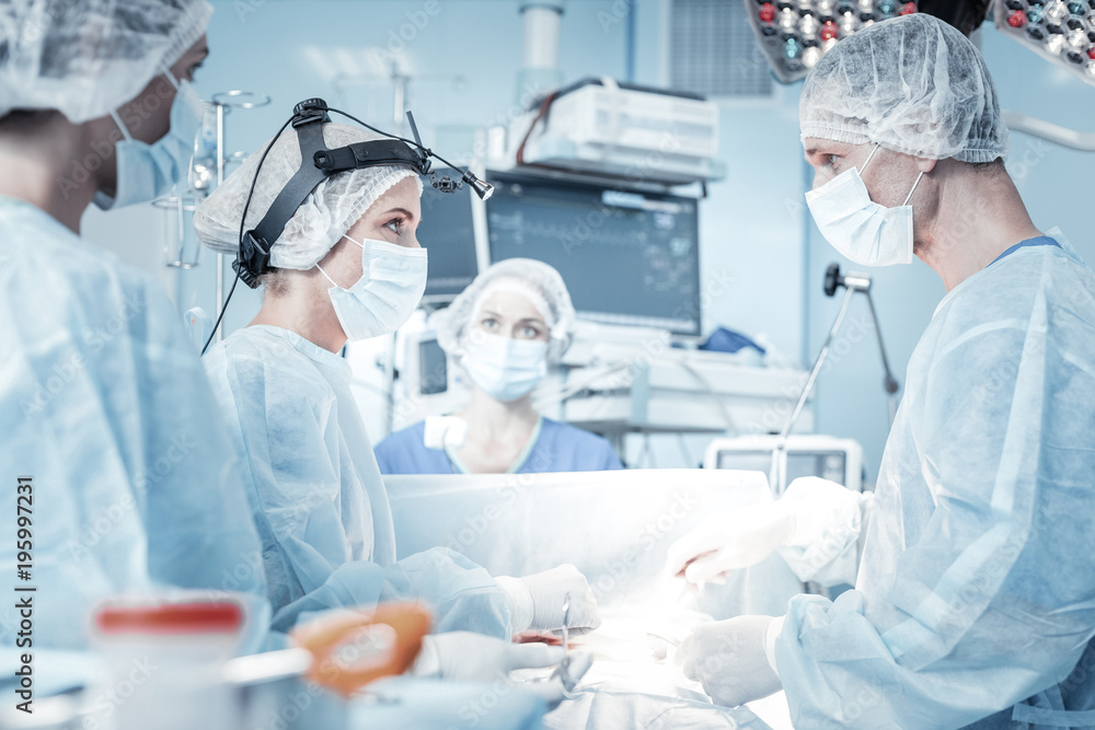 You will help me. Confident responsible skilled surges standing in the operational-room doing theirs work and looking at each other. You will help me. Confident responsible skilled surges standing in the operational-room doing theirs work and looking at each other.