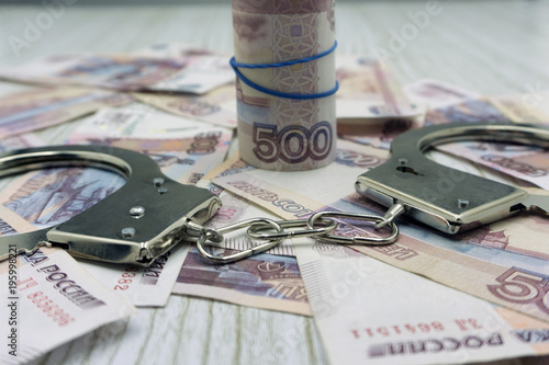 Handcuffs on the Envelope with Russian Rubles on the Table .