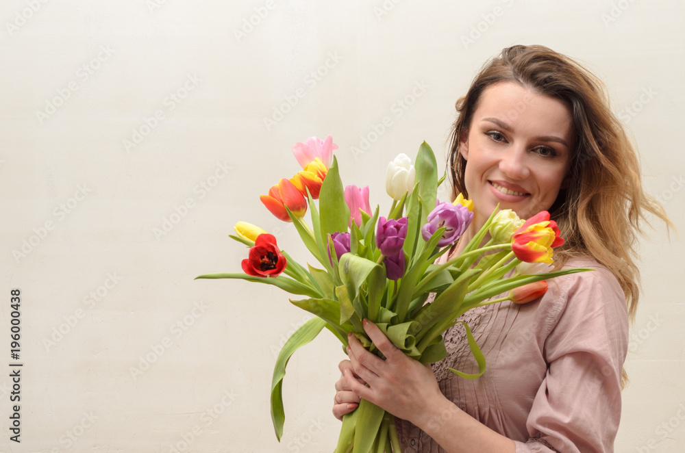Young charming girl with a bouquet of flowers - multi-colored tulips Young charming girl with a bouquet of flowers - multi-colored tulips