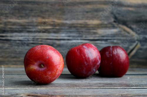 Plums on dark wooden background with copy space