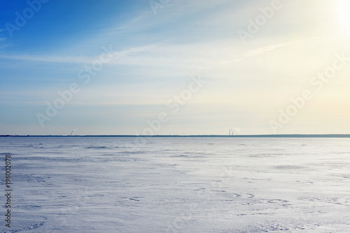 Deep blue sky and snow on frozen Baltic Sea with people walking on ice