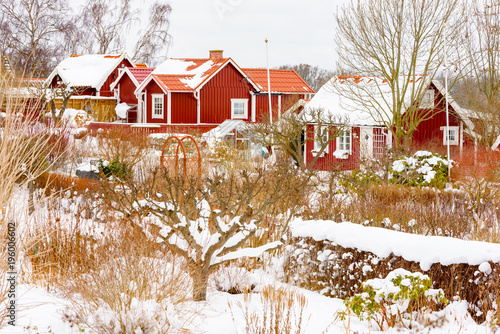 Allotment village Brandaholm in Karlskrona, Sweden, and gardens in late winter or early spring with thawing snow on cabin roofs. photo