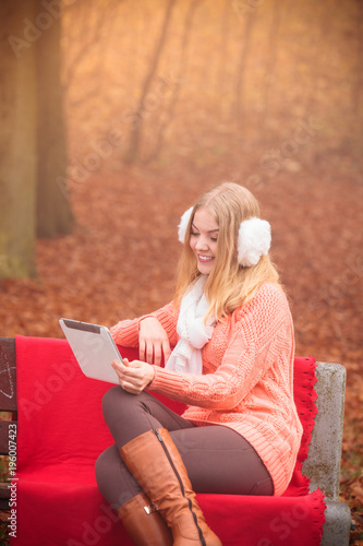 Woman with digital tablet in autumn park