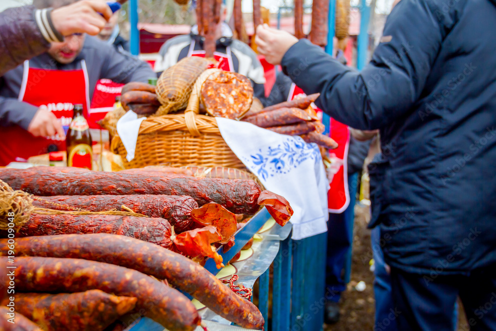 People are buying smoked meat on stall, street market